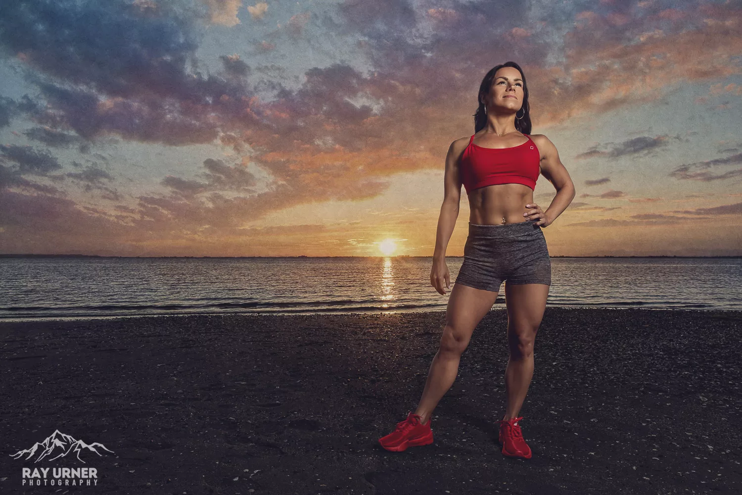 Figure athlete posing at the beach at sunset